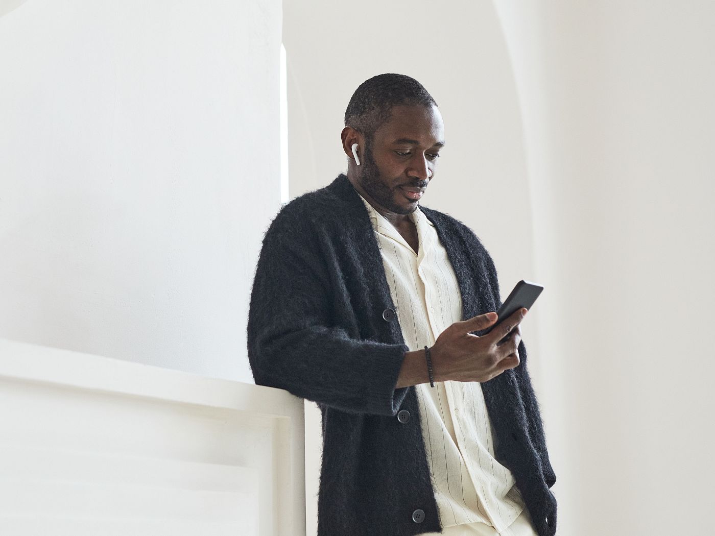 A man with a hearing device reads an update on his phone